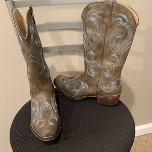 Brown cowboy boots with blue and white stitching.